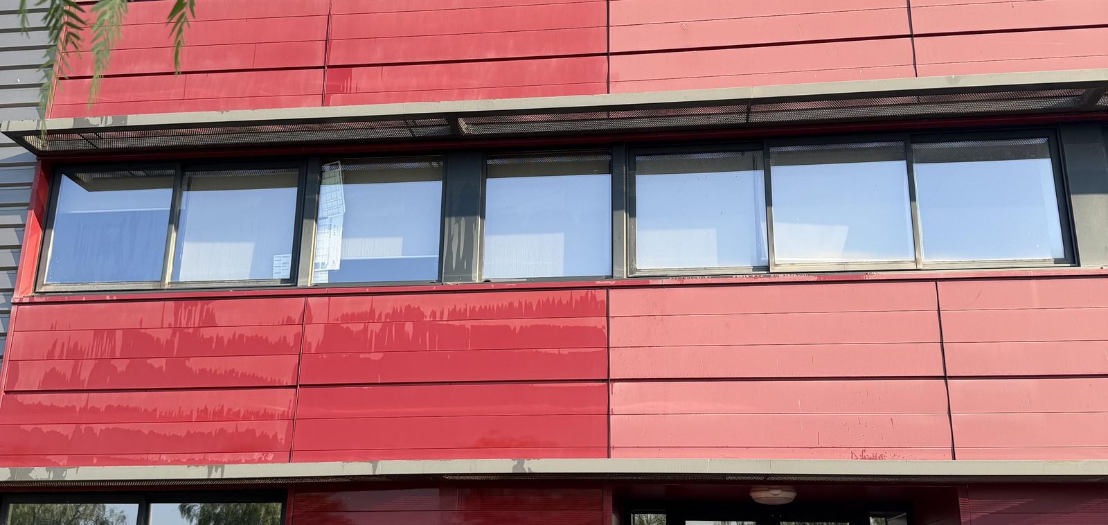 Bardage rouge en cours de nettoyage : la ligne entre partie propre et partie sale